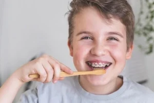 What Happens If You Have a Loose Tooth With Braces: When to Act and Why It Occurs 37 little boy with braces brushing teeth